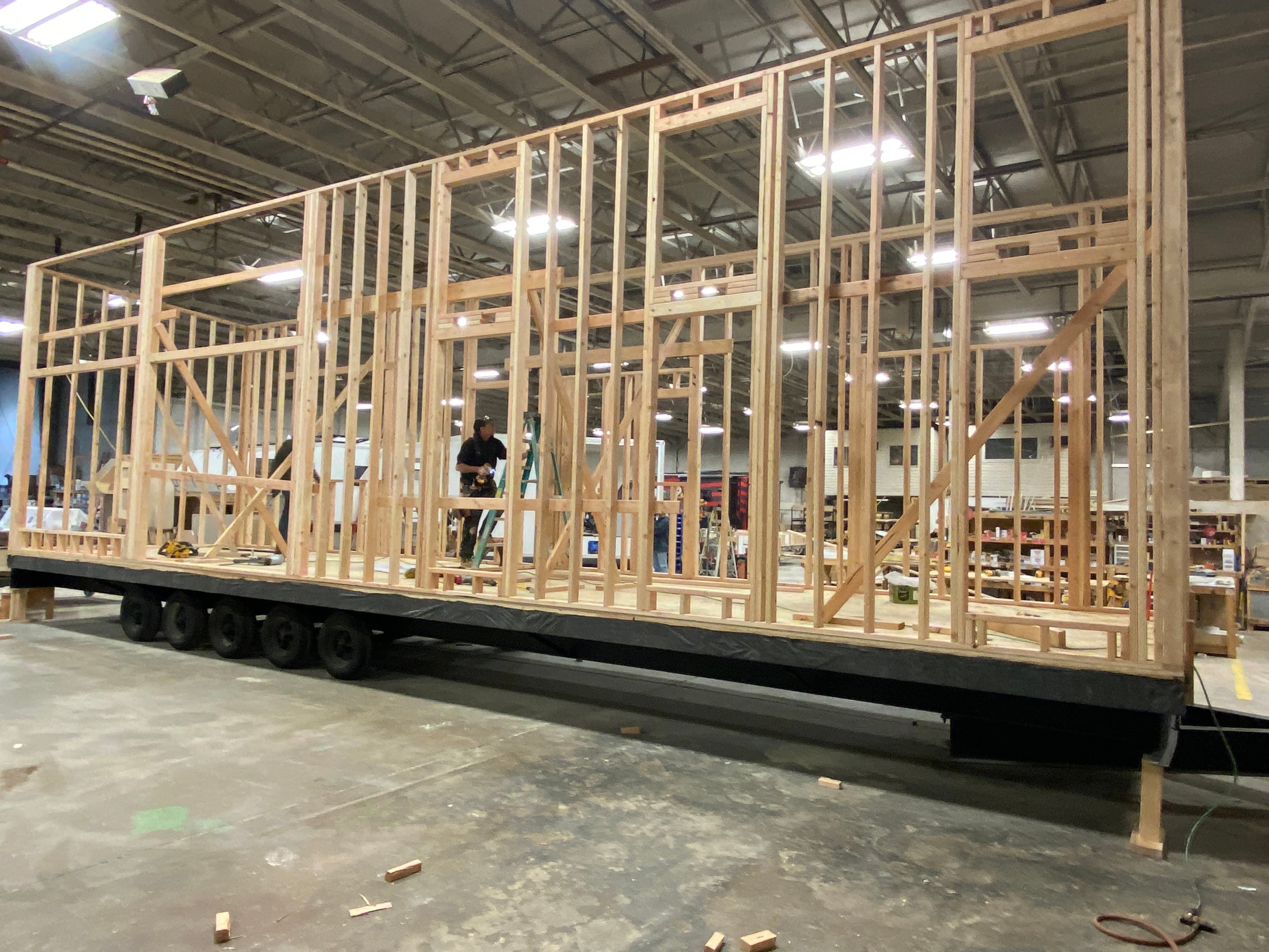 Montera Homes factory build — roof truss installation in climate-controlled facility
